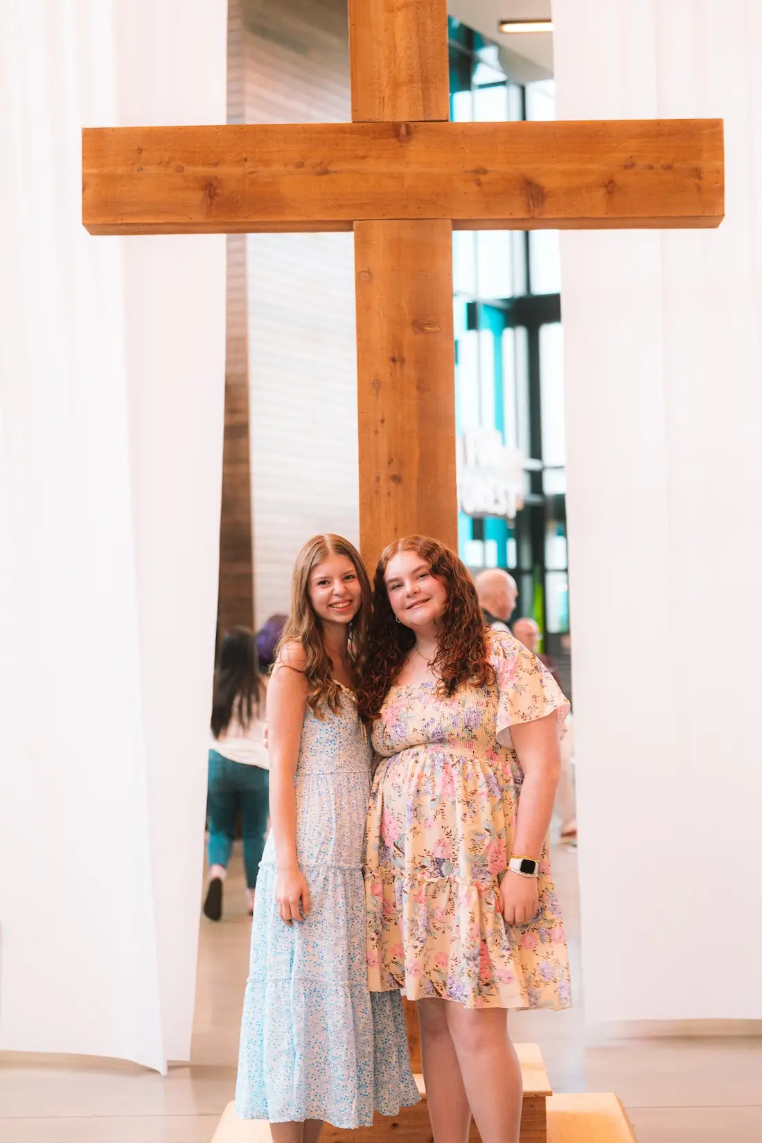 Two children standing beside a wooden cross