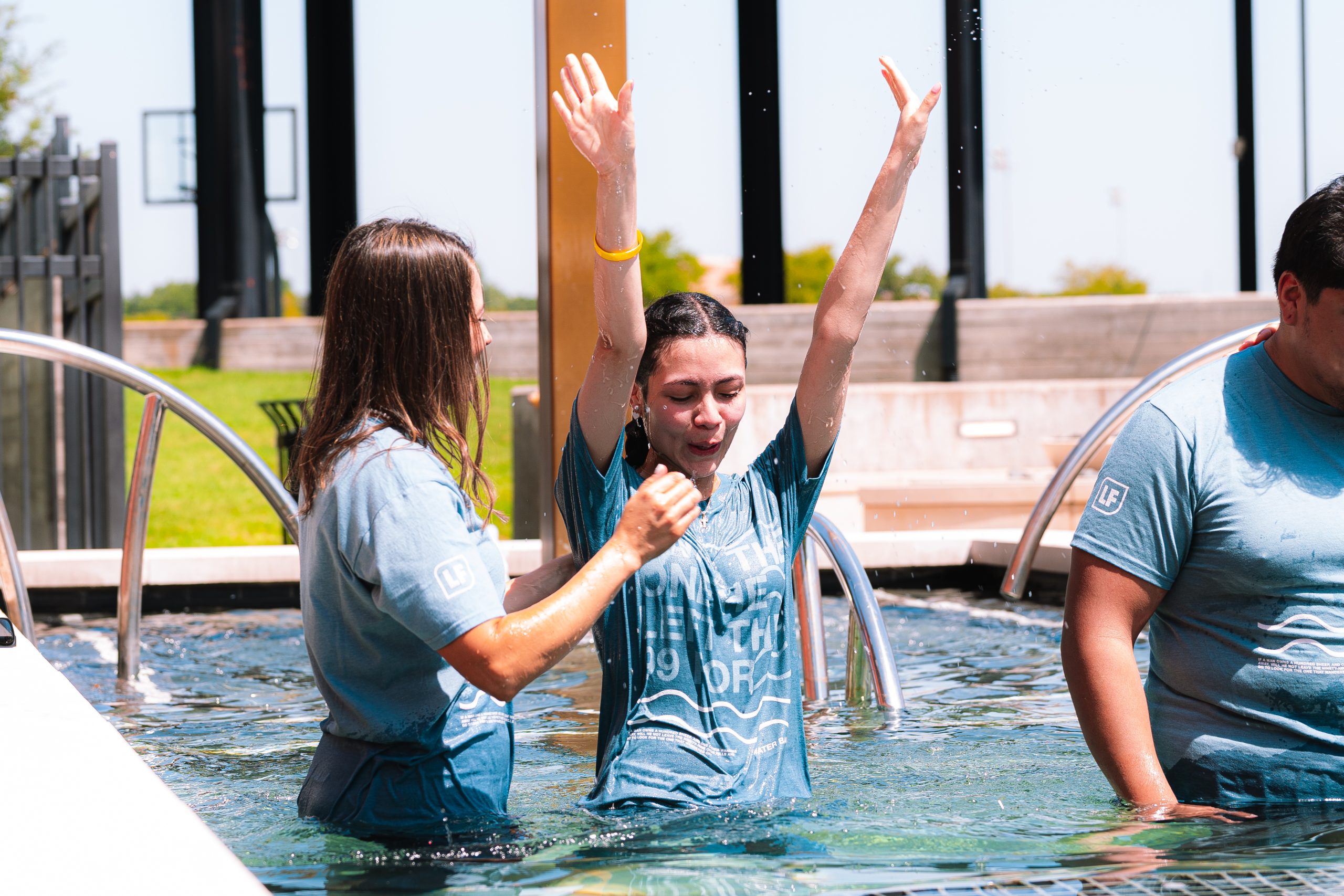 A participant raises her hands after being baptized at Life Fellowship.