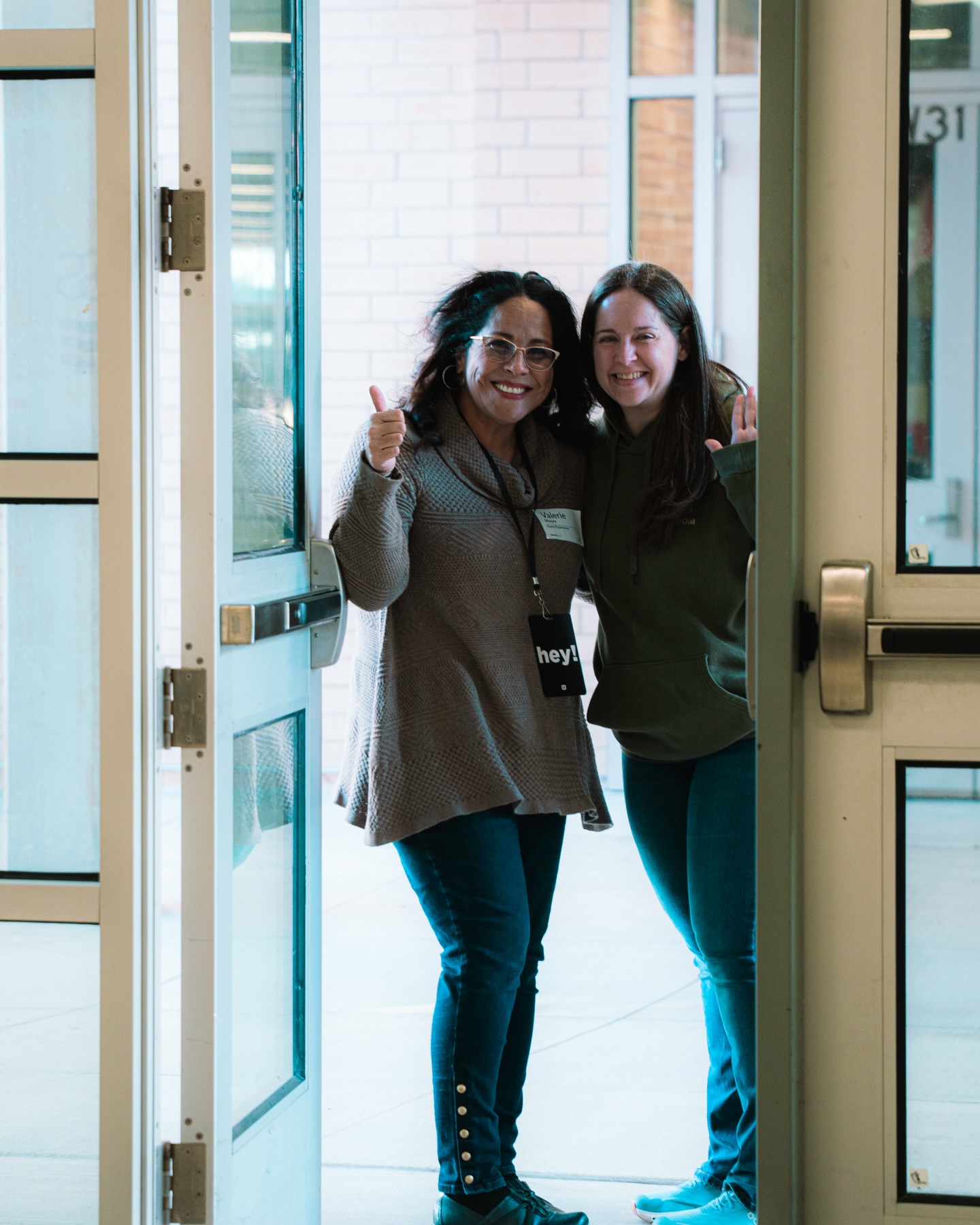 Two people stand together at an open church doorway.