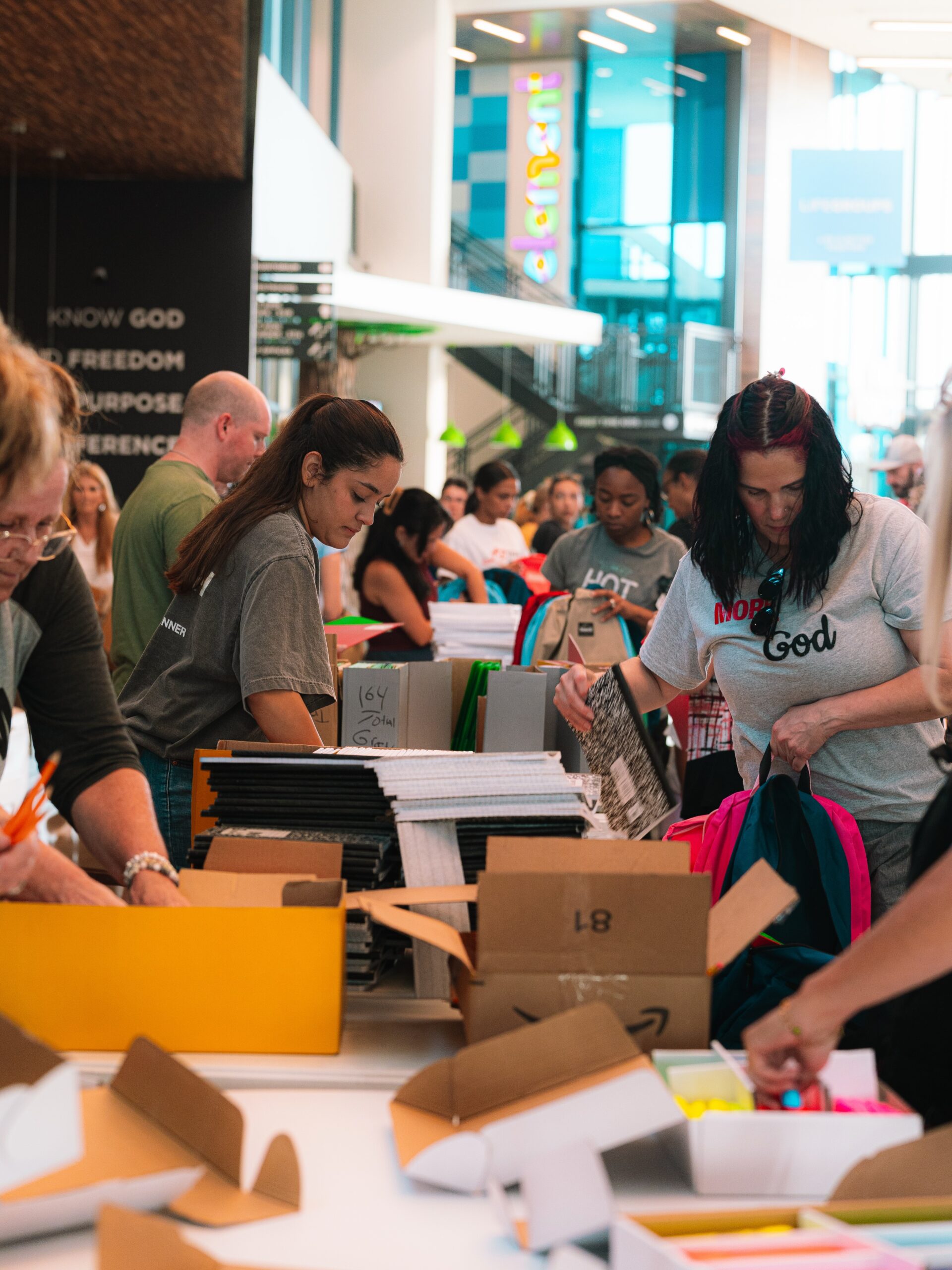 Volunteers pack supplies together at tables inside the church.