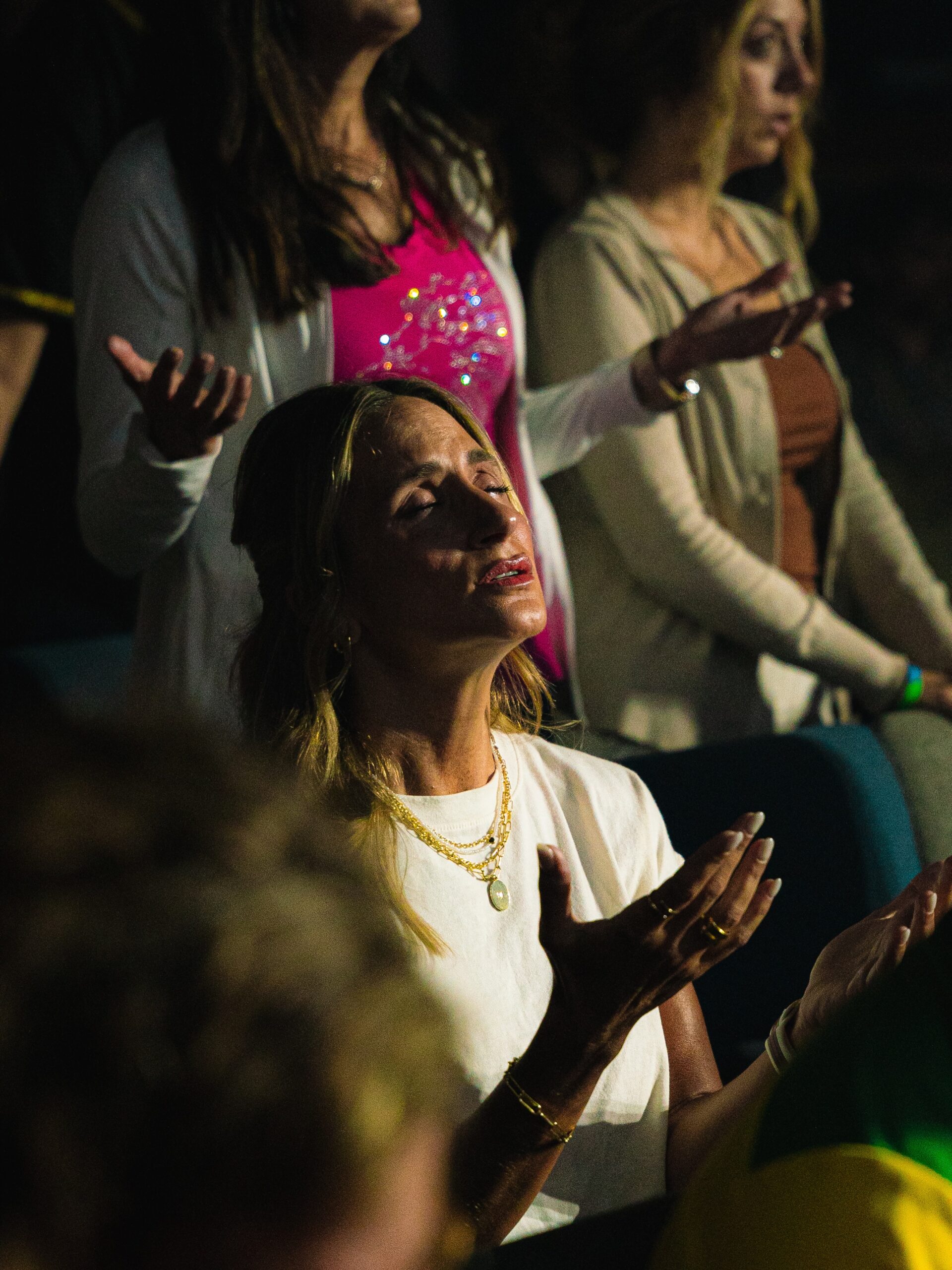 Members of the congregation worship together with open hands.