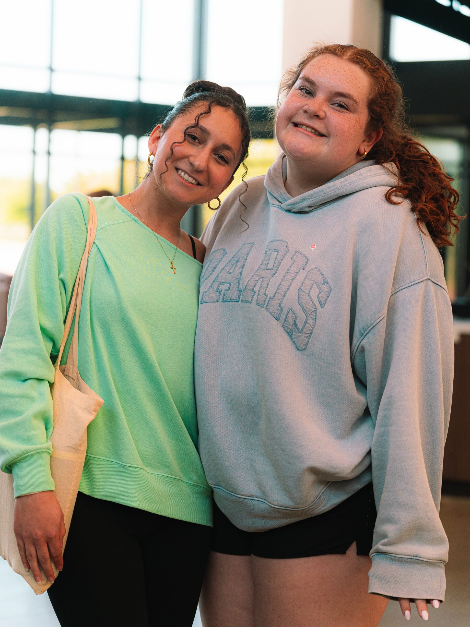 Two students smile together during a youth gathering.